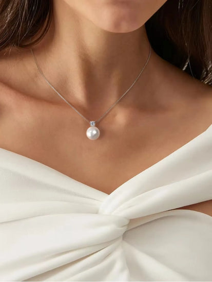 Elegant woman wearing Maris Pearl Necklace featuring a radiant pearl and zirconia on a silver chain.
