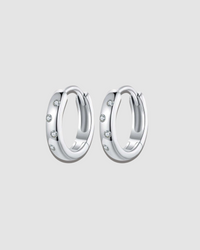 Pair of silver hoop earrings with small stones on a white background