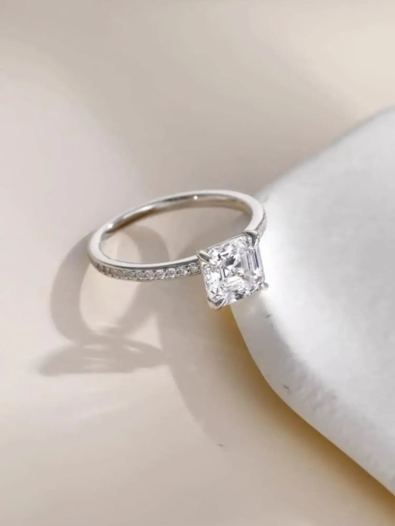 2CT Asscher Cut CZ wedding ring in sterling silver, showcasing clarity and vintage charm on a soft background.