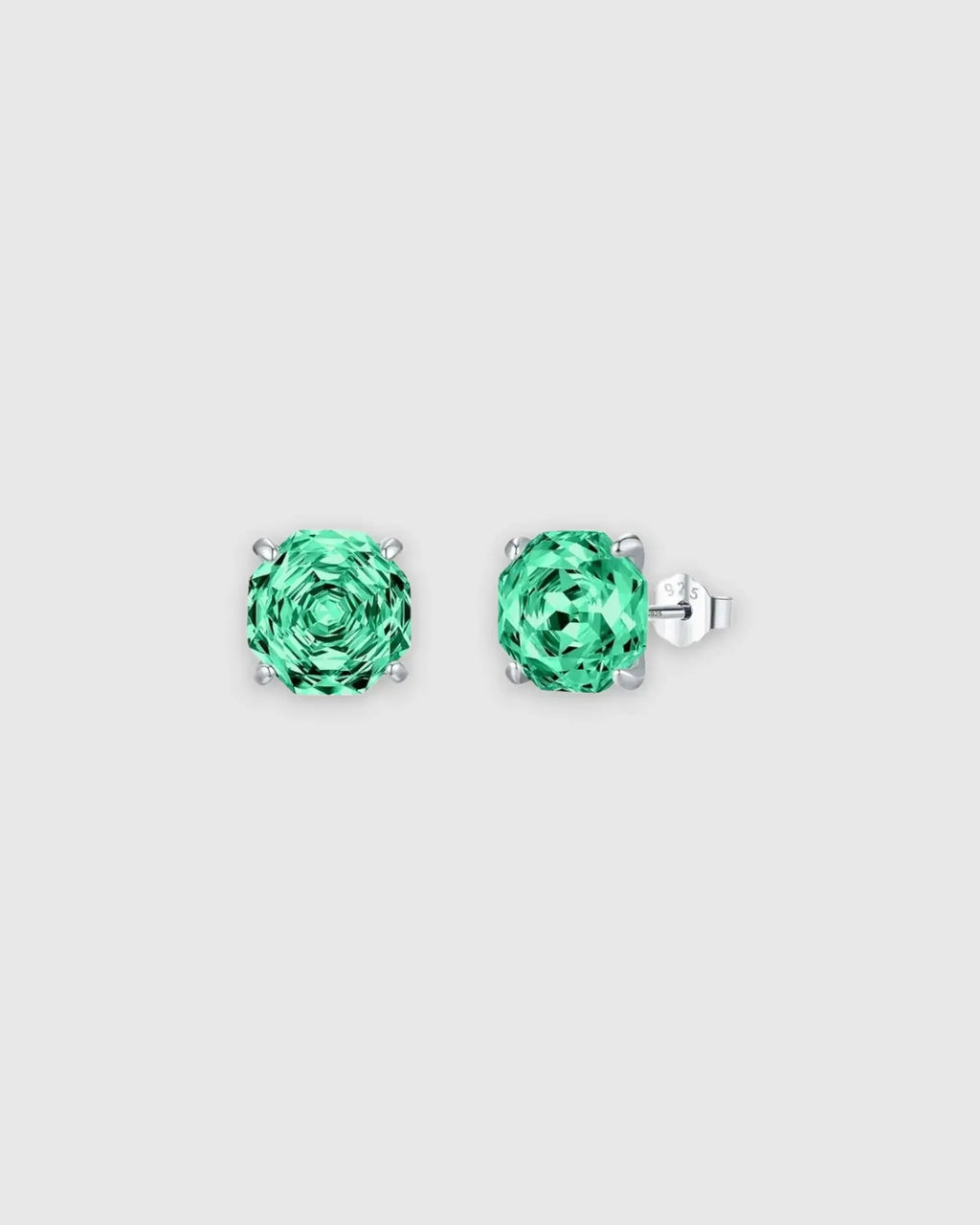 Pair of green stud earrings on a light gray background