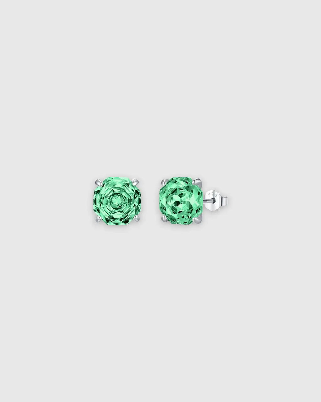 Pair of green gemstone stud earrings on a light gray background