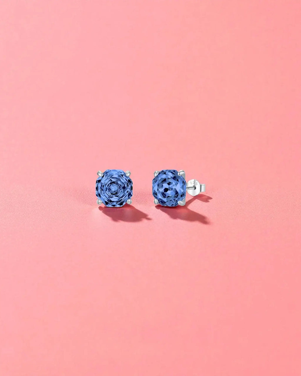 Octagonal Rose Cut Tanzanite Blue  Zircon Stud in Silver earrings against a pink background.