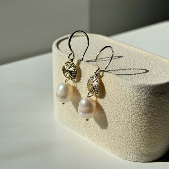 A pair of gold pearl earring