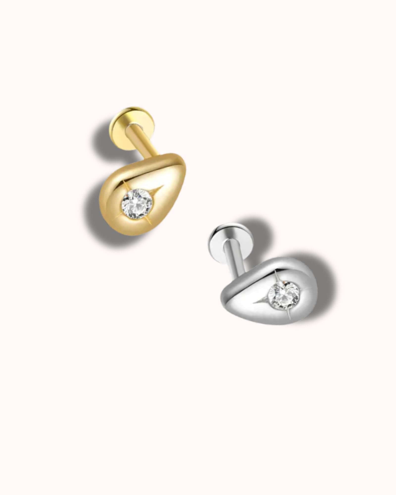 Gold and silver earrings with clear gemstones on a white background