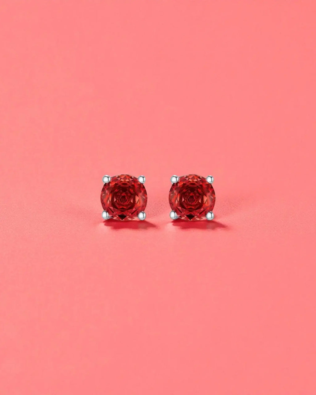 Octagonal Rose Cut Deep Red Zircon Stud in Silver displayed on a pink background.