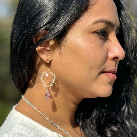 A woman wearing a beautiful gemstone earring in gold filled