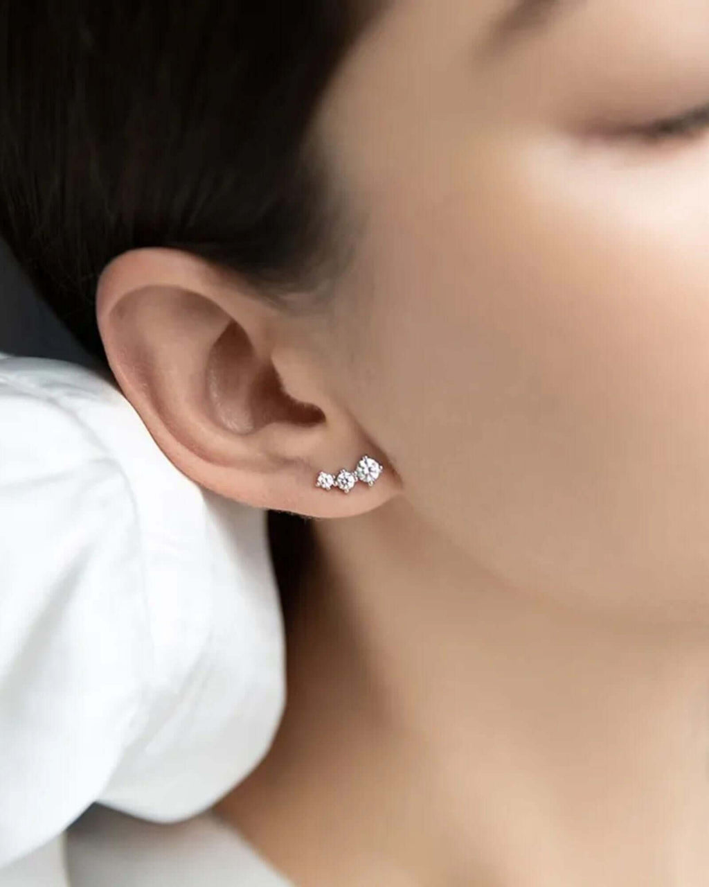 Close-up of rhombus stud earrings in Silver worn on model's ear