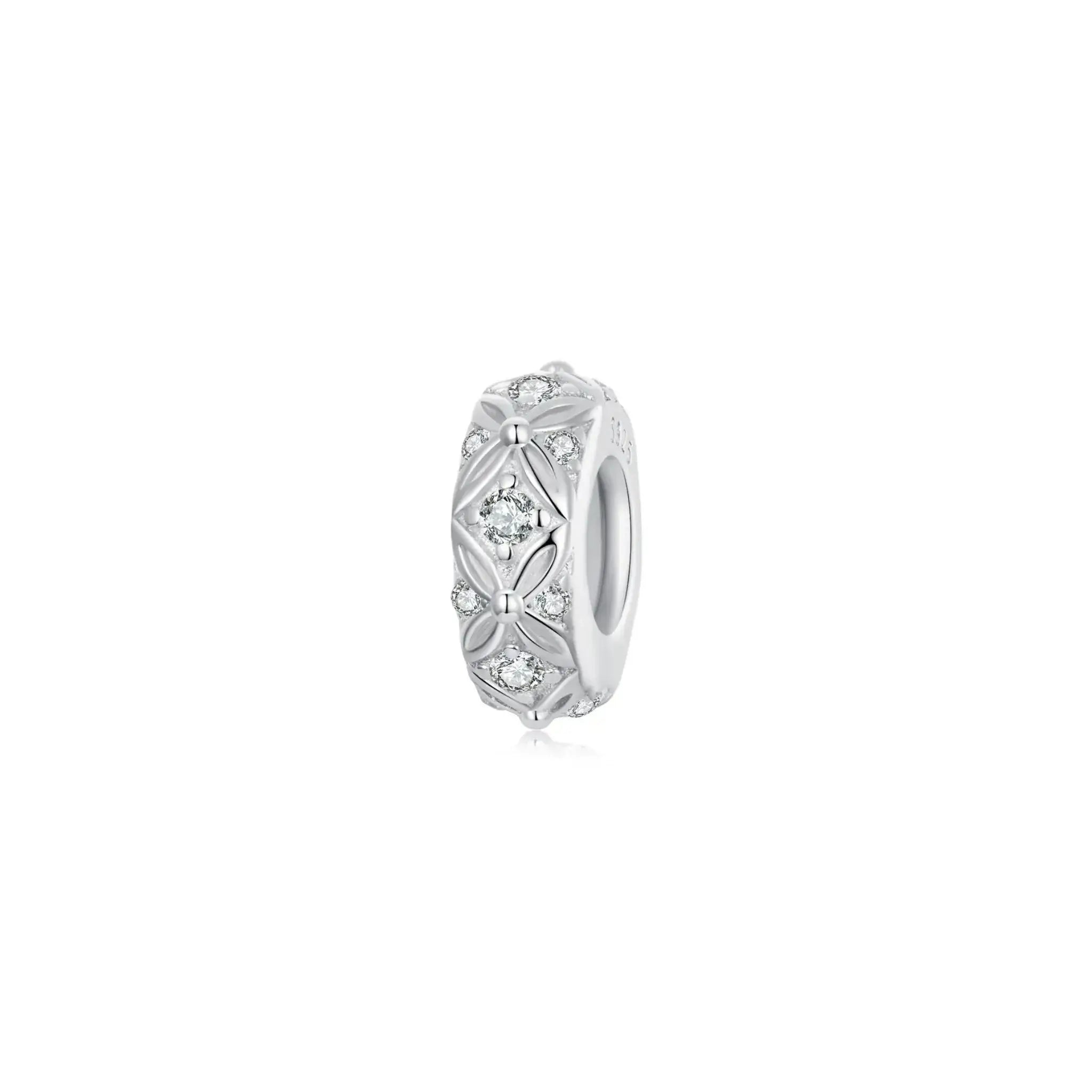 Silver ring with intricate design and clear gemstones on a white background