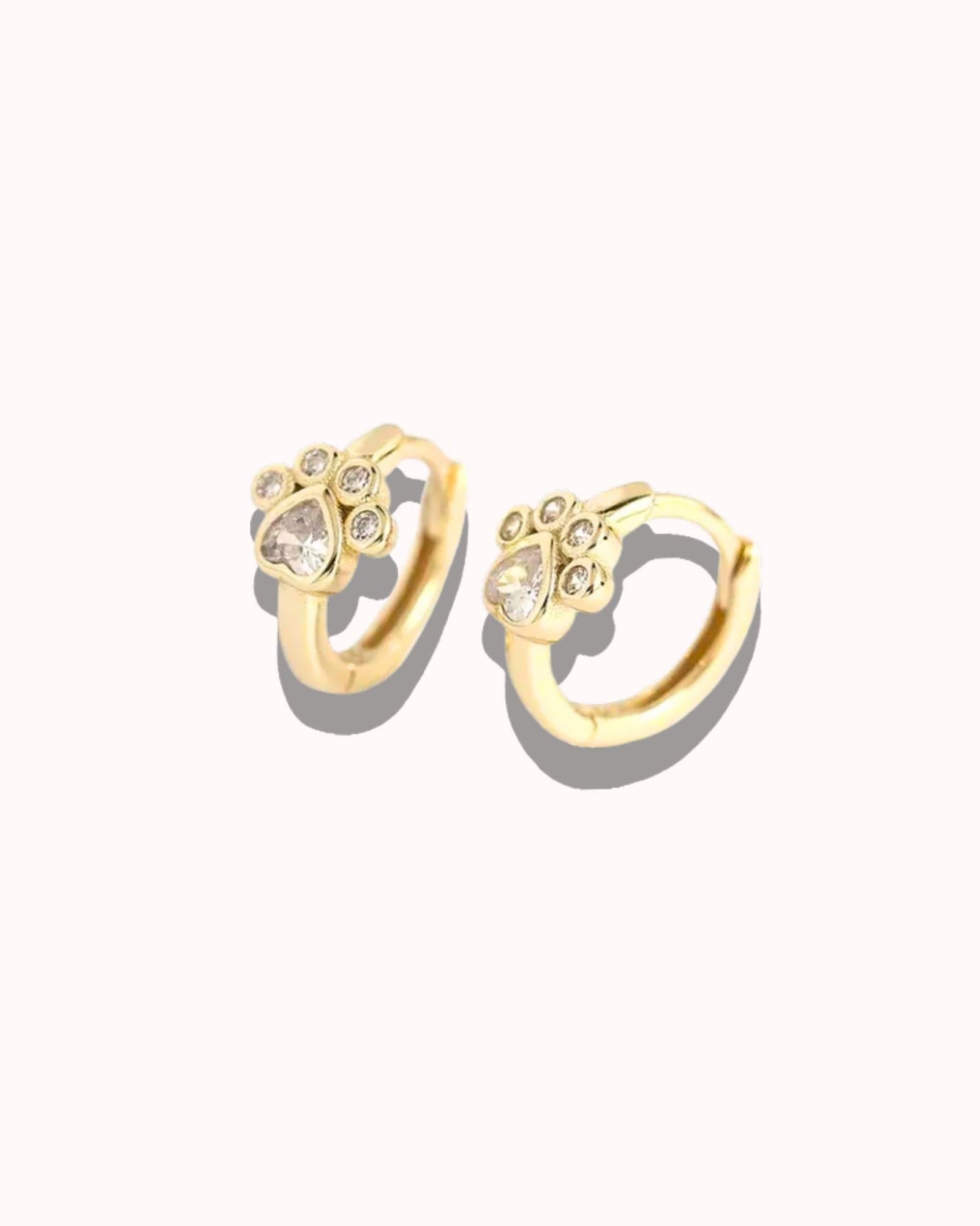 Gold hoop earrings with small stones on a white background