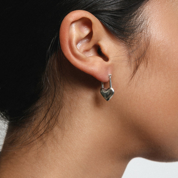 a women wearing the locked heart earring beautifully.