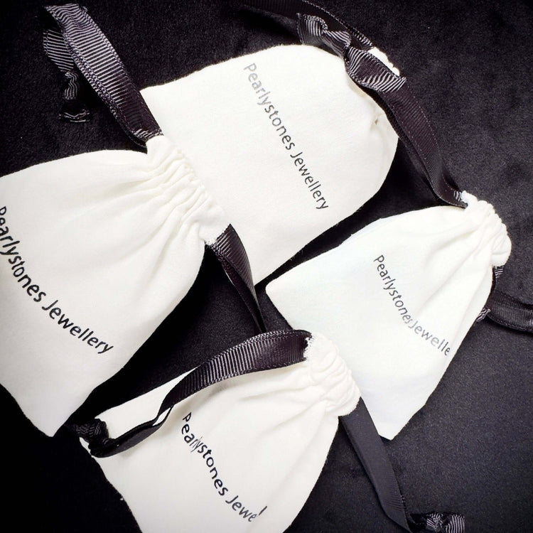 packaging jewellery in a white cotton pouch with black ribbon 