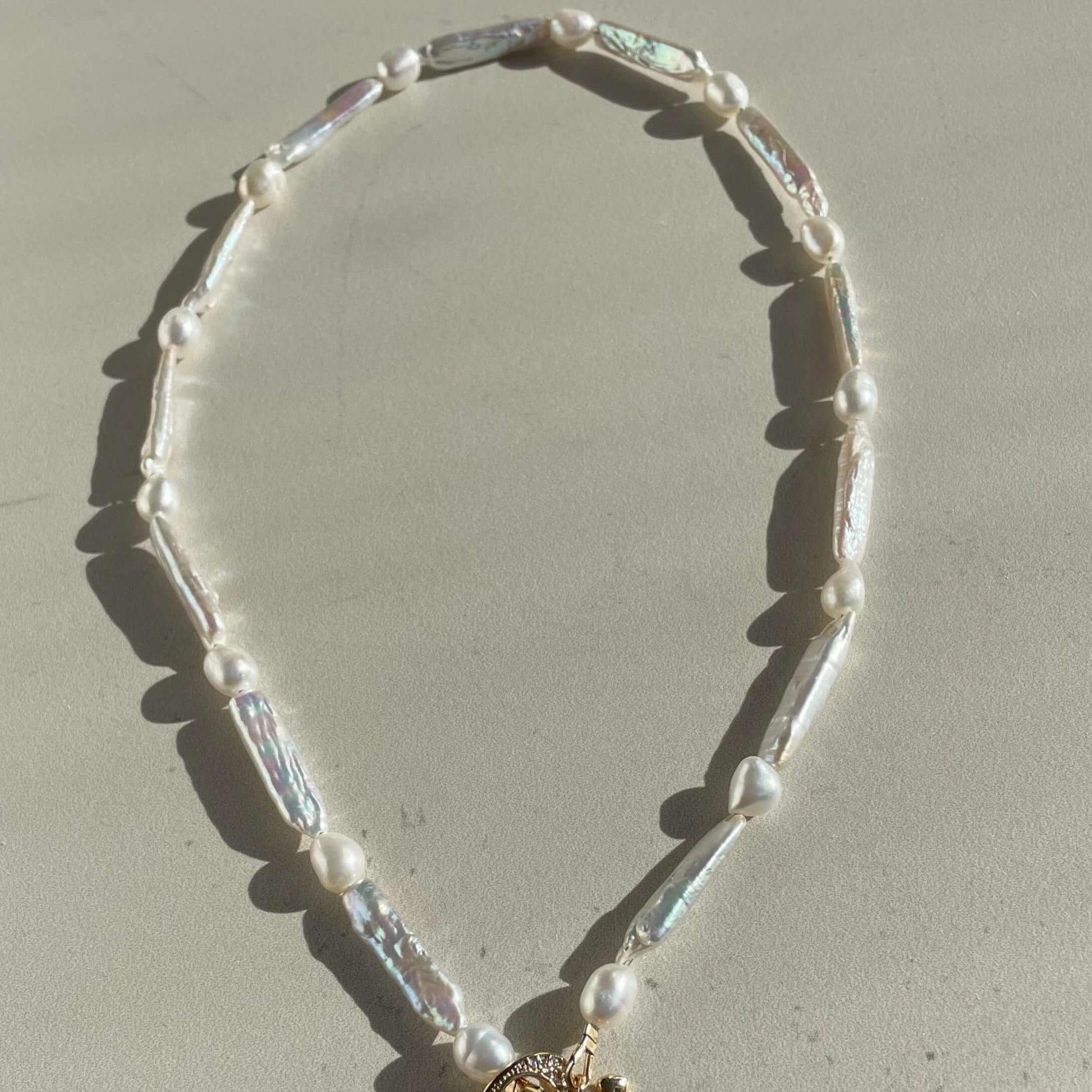 A biwa pearl necklace with heart toggle is displayed. clasp 