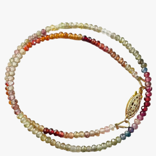 A beautiful multi sapphire beaded necklace is displayed in a white background, The 14 inches necklace features a turtle shaped toggle and clasp.