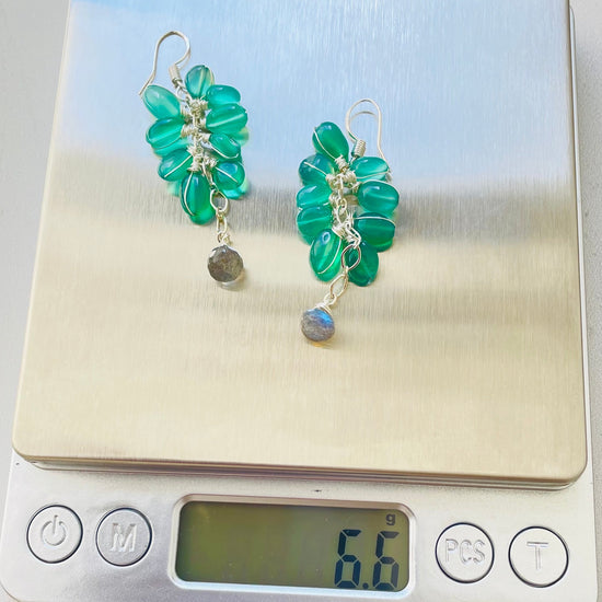 A beautiful green onyx and labradorite gemstone cluster earring on a weighing scale to show the weight is 6.6 g