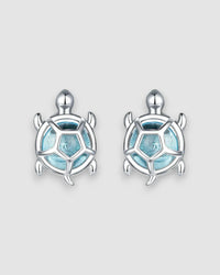 Sea Turtles Stud Earrings in Silver with blue glass stones and platinum-plated settings.