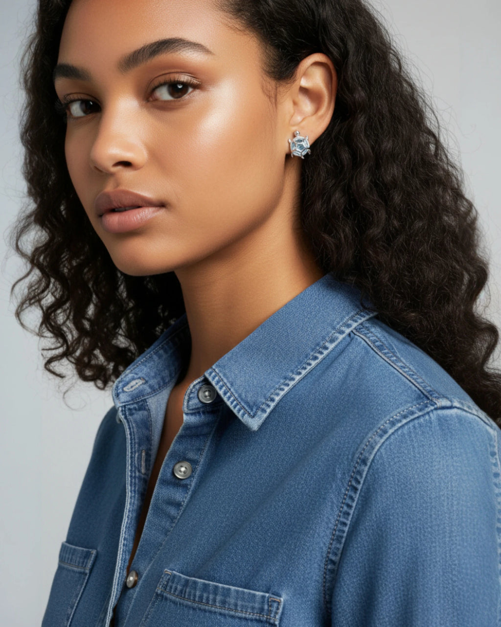 A model showcasing Sea Turtles Stud Earrings in Silver, featuring a blue glass stone and a platinum-plated setting.