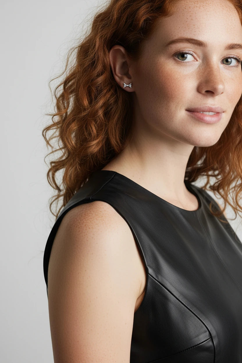 Model wearing Small Bow Earrings in Sterling Silver, showcasing understated elegance with a stylish outfit.