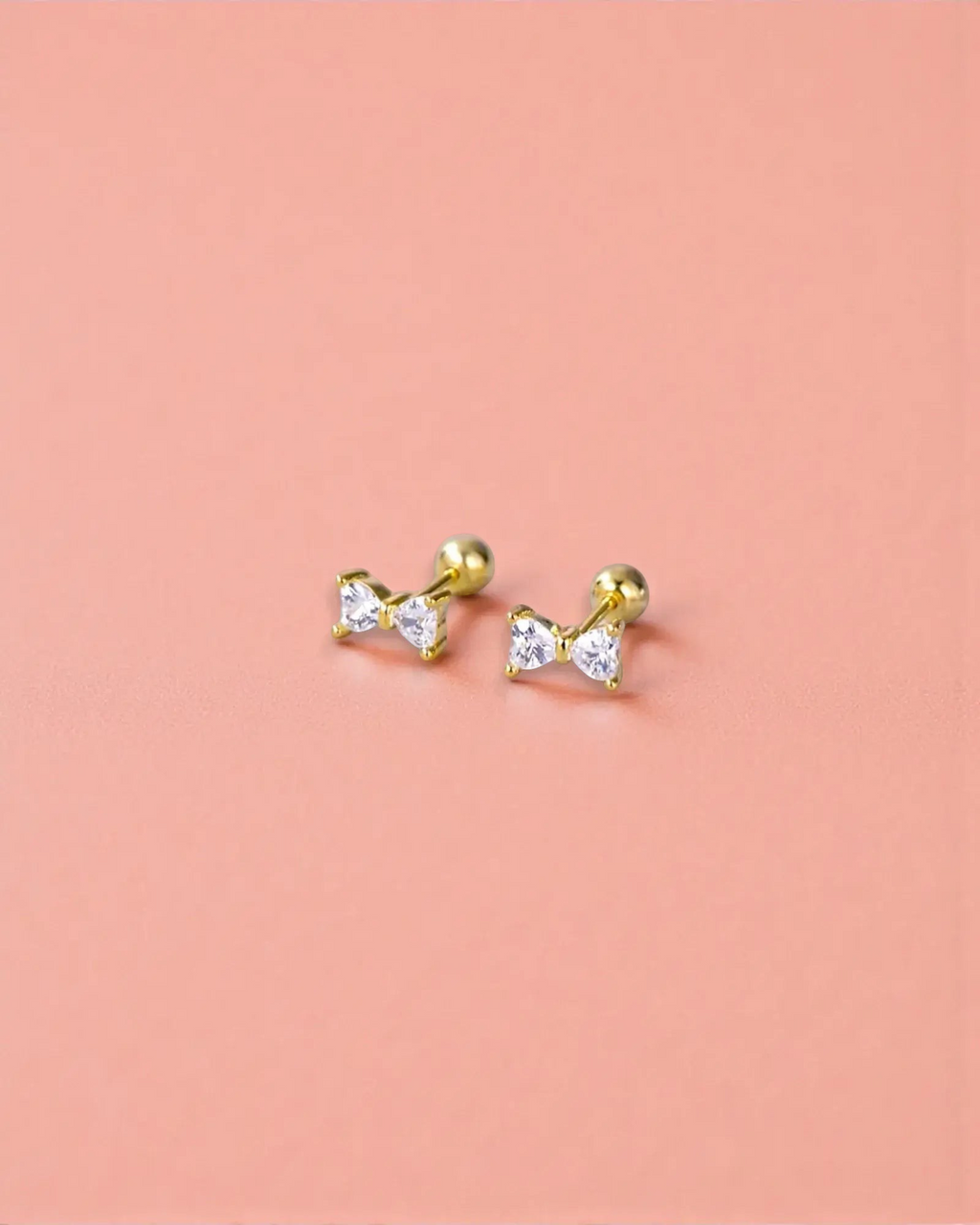 Small bow stud in Gold with sparkling zirconia stones and ball screw back for secure fit.