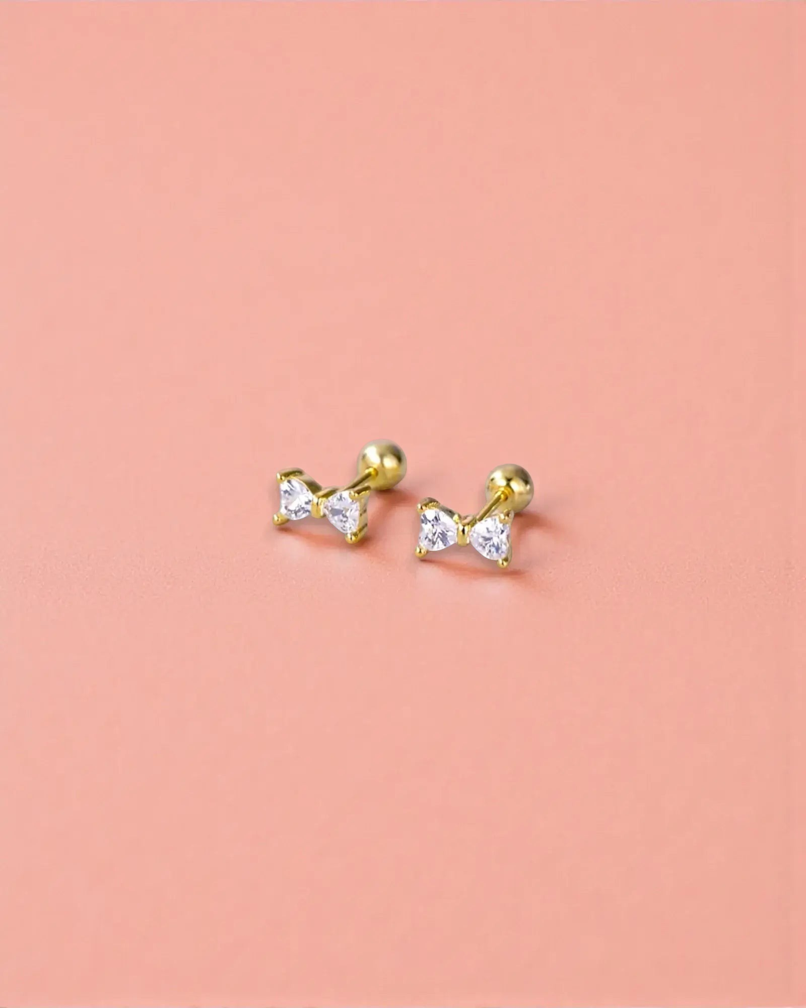 Small bow stud in Gold with sparkling zirconia stones and ball screw back for secure fit.