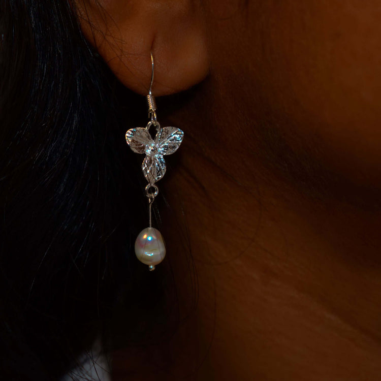 A woman wearing Pearl earrings in sterling silver