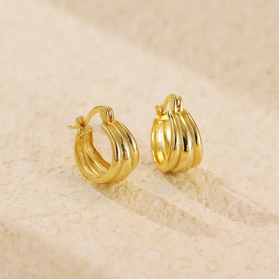 Aura Curve Hoop Earrings in gold, featuring a sleek, sculptural design with wave-like curves.