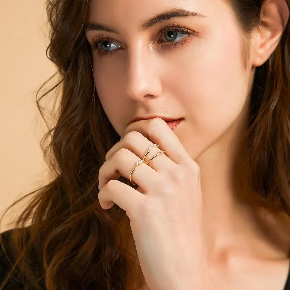 Woman wearing the Aurum Arc Ring, featuring a curvy design and sparkling cubic zirconia, enhancing her elegant look.