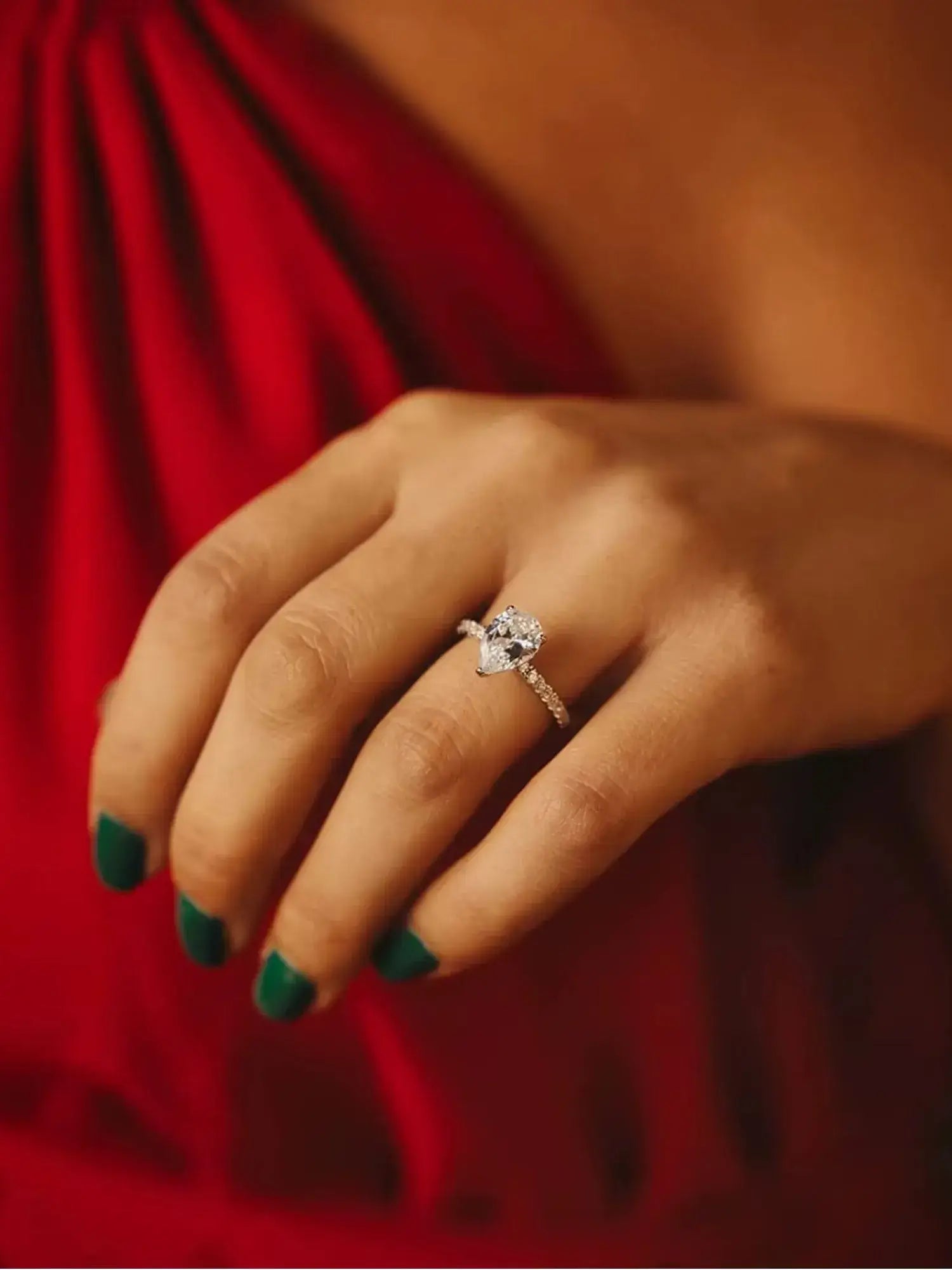 Elegant Golden Promise Engagement Ring showcased on a hand, featuring a sparkling water drop-shaped cubic zirconia.