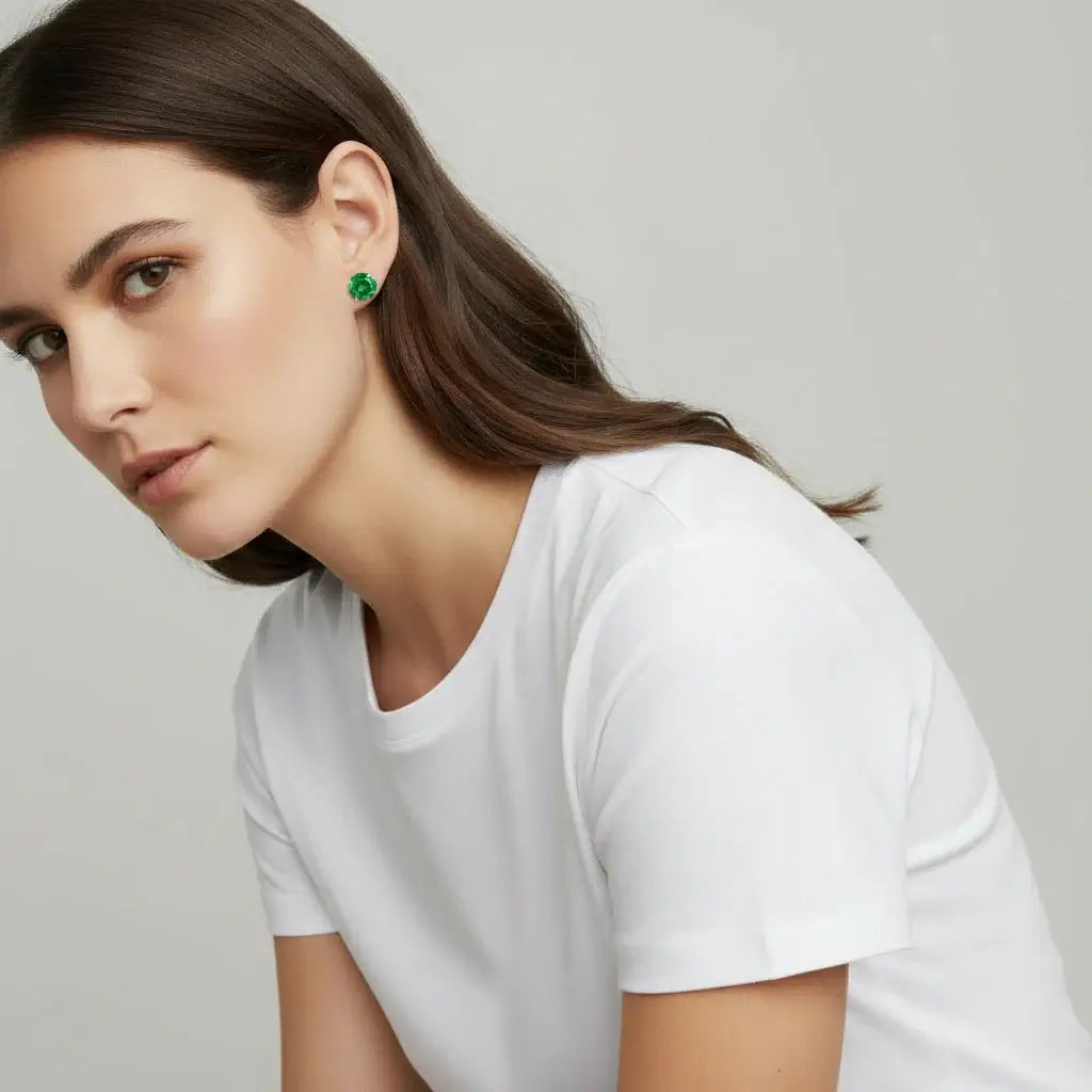 Woman wearing green earrings against a plain background