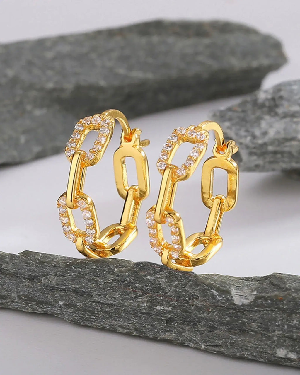 Hollow Chain Link Luxe Hoops featuring gold plating and AAA cubic zirconia accents on a stone background.