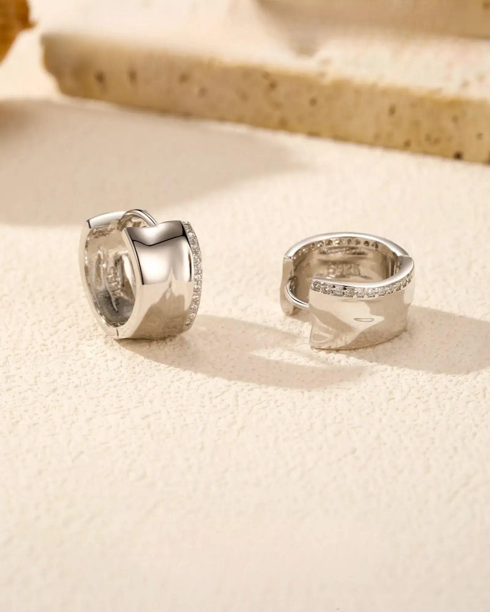 Irregular small zircon hoop earrings in 925 sterling silver with rhodium finish, showcasing modern geometric design and sparkle.
