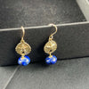 A pair of beautiful natural lapis lazuli earrings are displayed on a black background