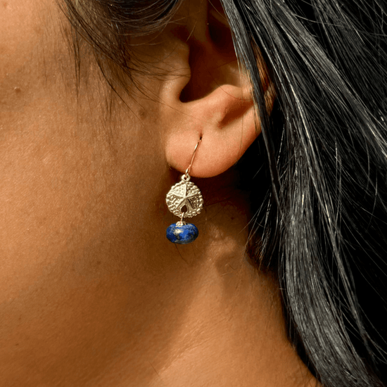 A women wearing a beautiful lapis lazuli gemstone earring in gold filled material.