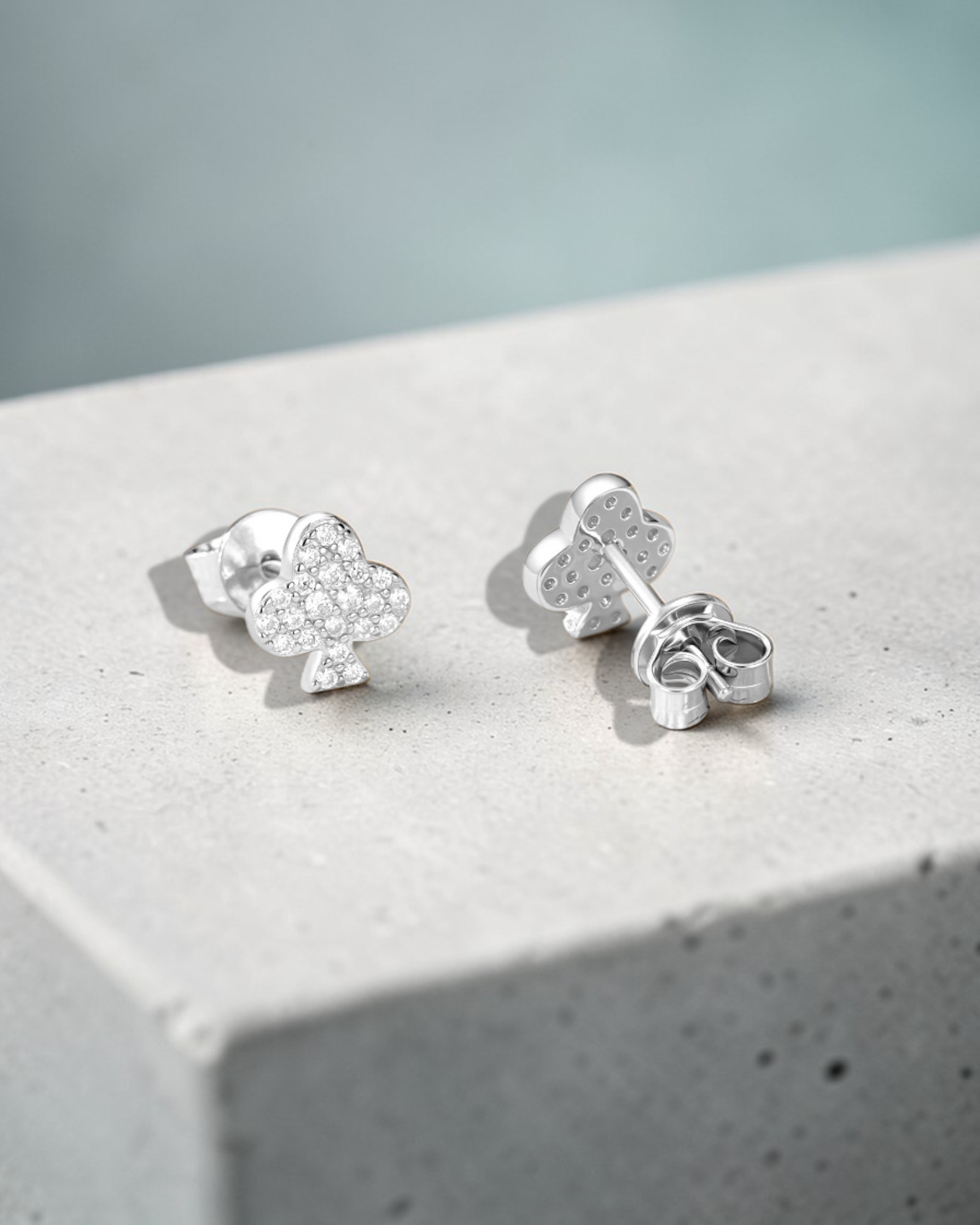 0.2 Ct Moissanite Clover leaf stud showcasing sparkling moissanite stones in a clover design on a marble surface.