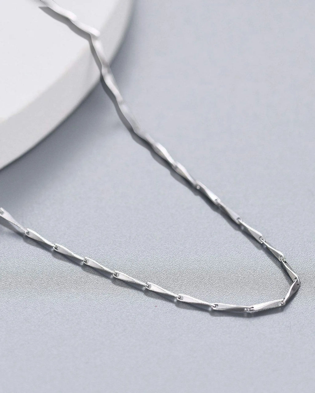 1mm Twisted Dapped Bar Chain made of S925 sterling silver with rhodium plating for a brilliant finish.