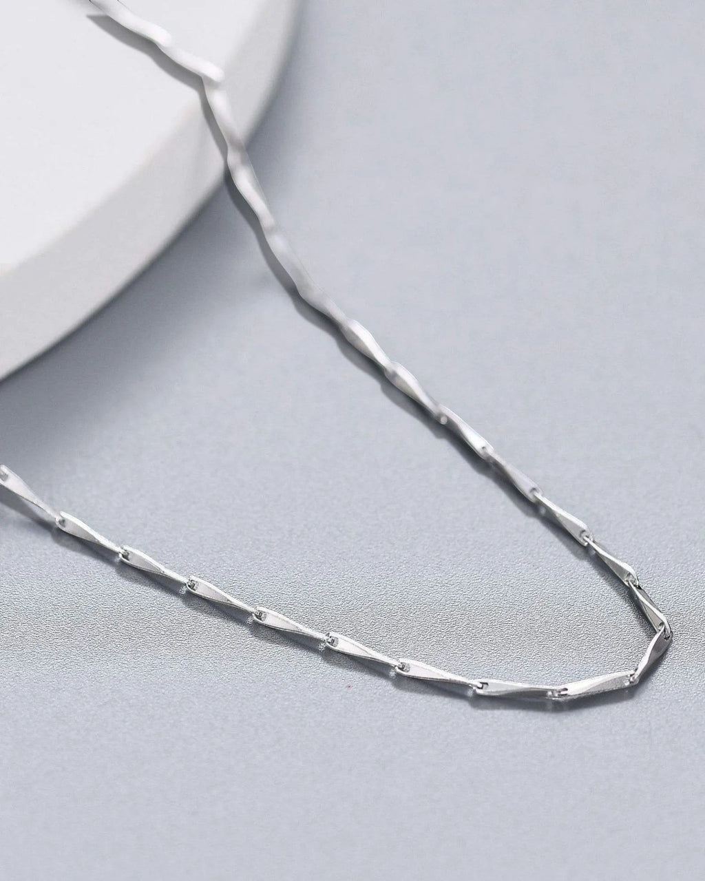 1mm Twisted Dapped Bar Chain made of S925 sterling silver with rhodium plating for a brilliant finish.