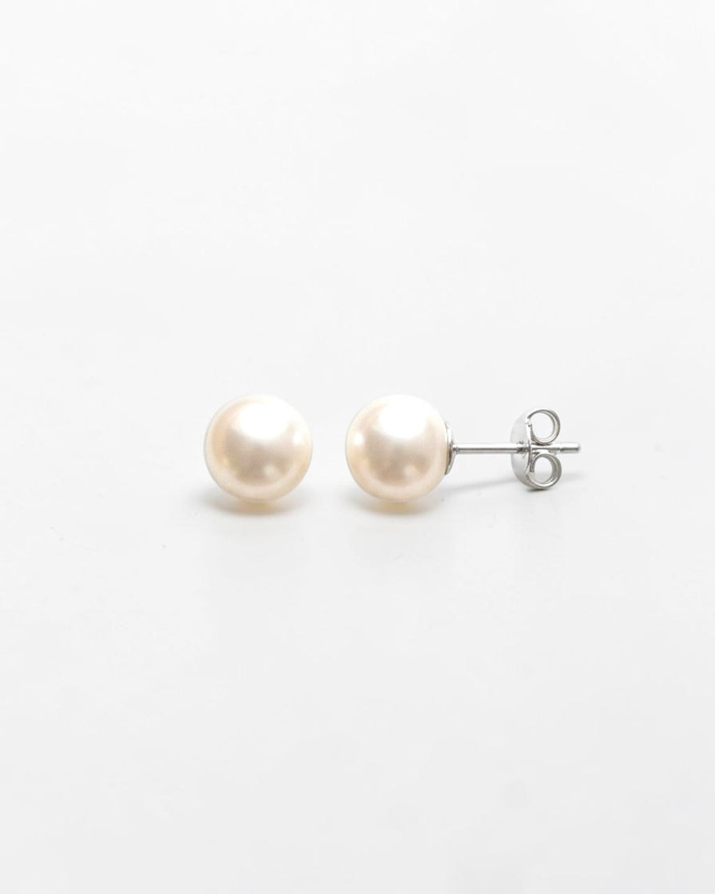 Pearlystones Aluna pearl stud earrings in sterling silver with white gold finish. Classic freshwater pearl design.