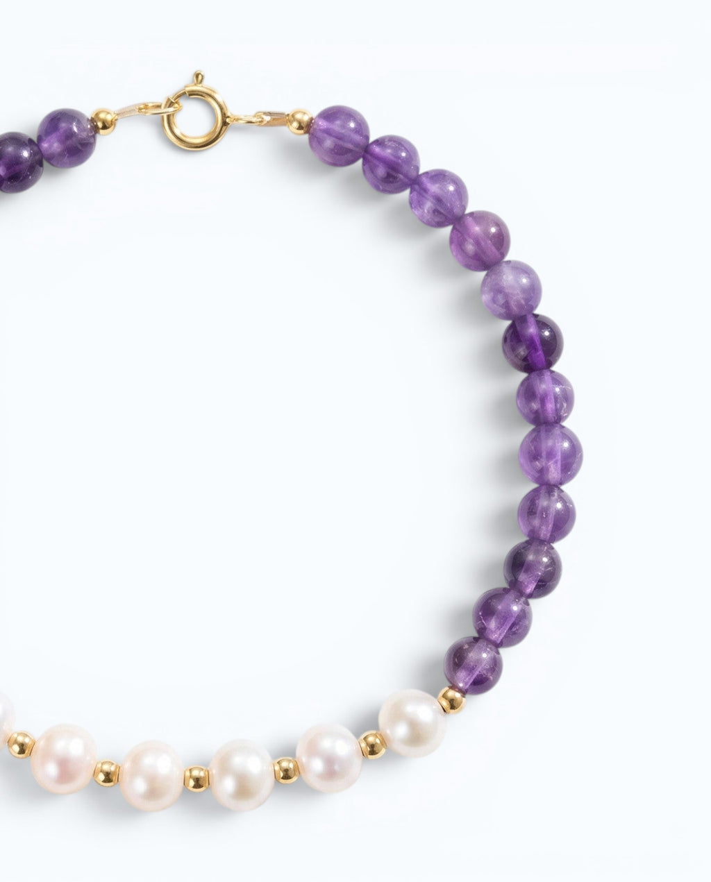 Pearlystones beaded bracelet featuring vibrant purple amethyst gemstones and lustrous white pearls with gold spacers.