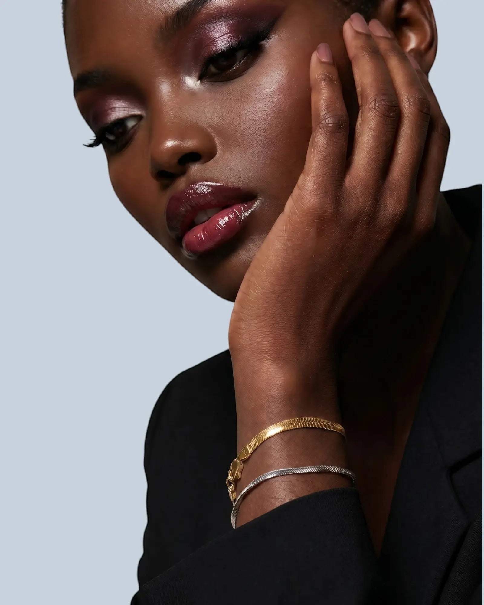 Pearlystones 3mm flat snake chain bracelet in gold and silver finishes, worn by a model.