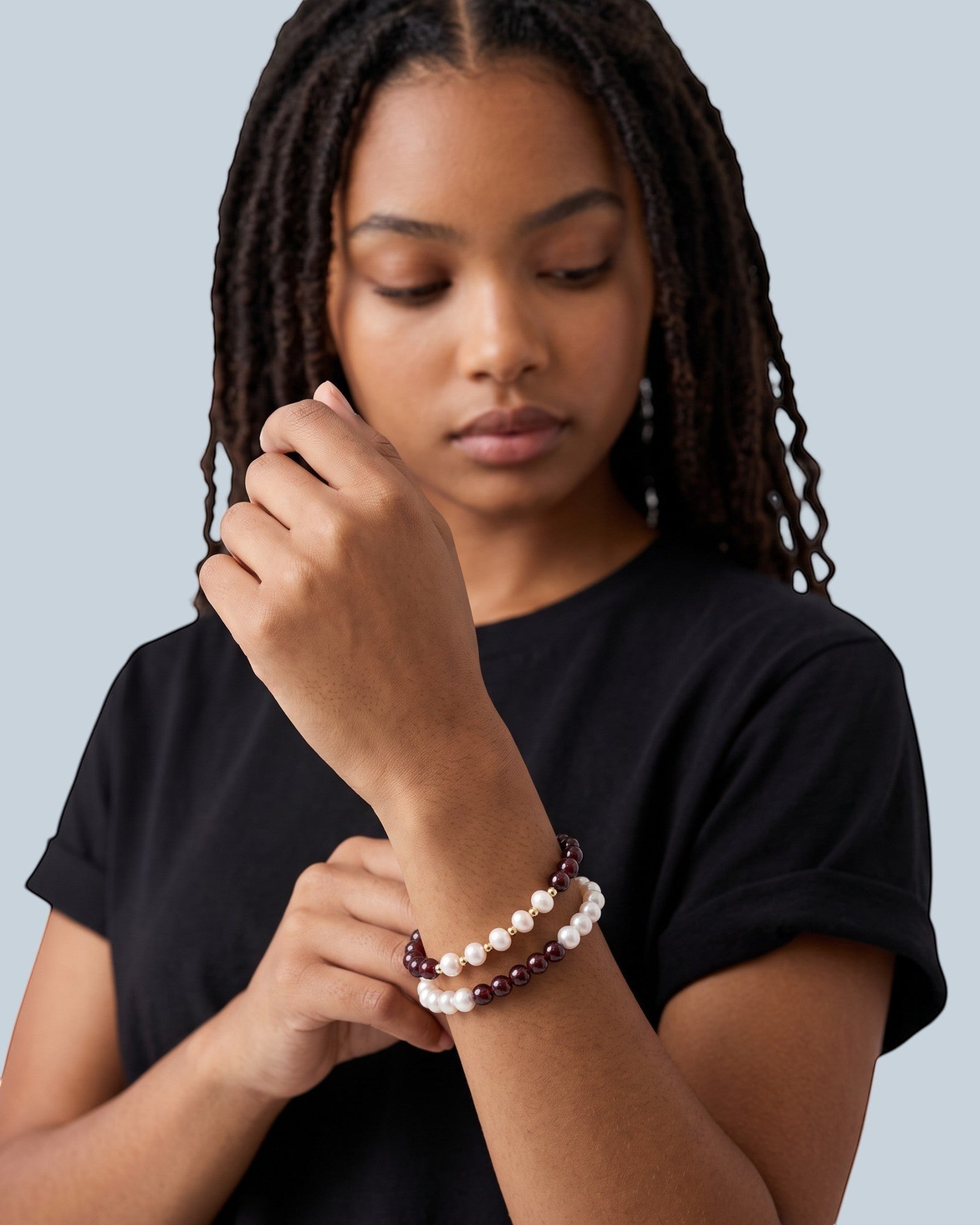 Pearlystones beaded bracelet featuring white pearls and deep red garnet gemstones with gold spacers on a model's wrist
