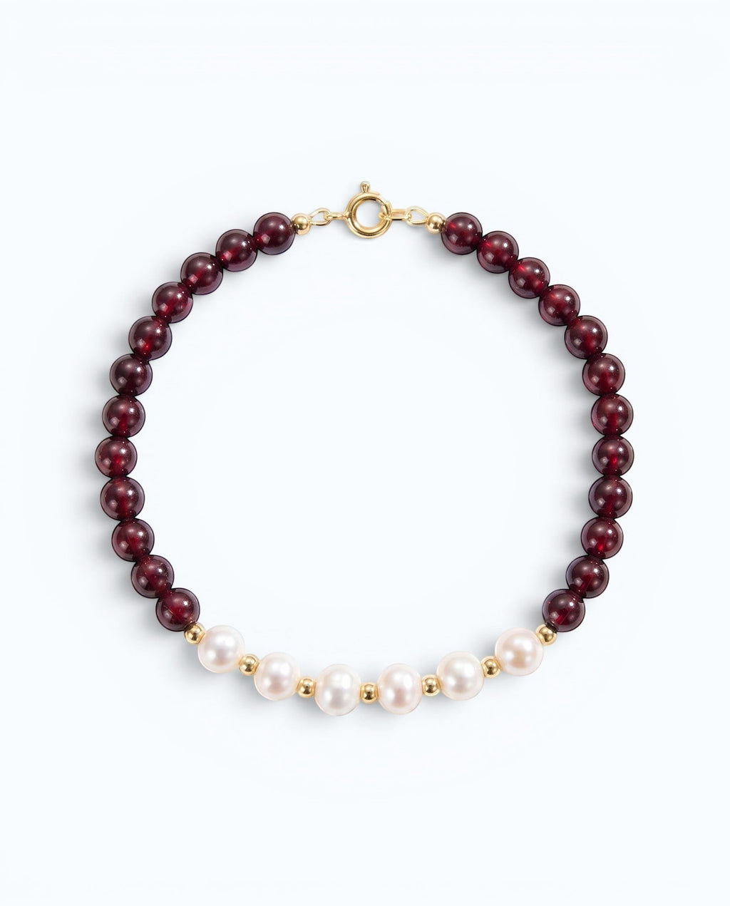 Pearlystones bracelet featuring deep red garnet beads and white pearls with gold-toned spacers and a secure clasp.