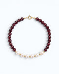Pearlystones bracelet featuring deep red garnet beads and white pearls with gold-toned spacers and a secure clasp.