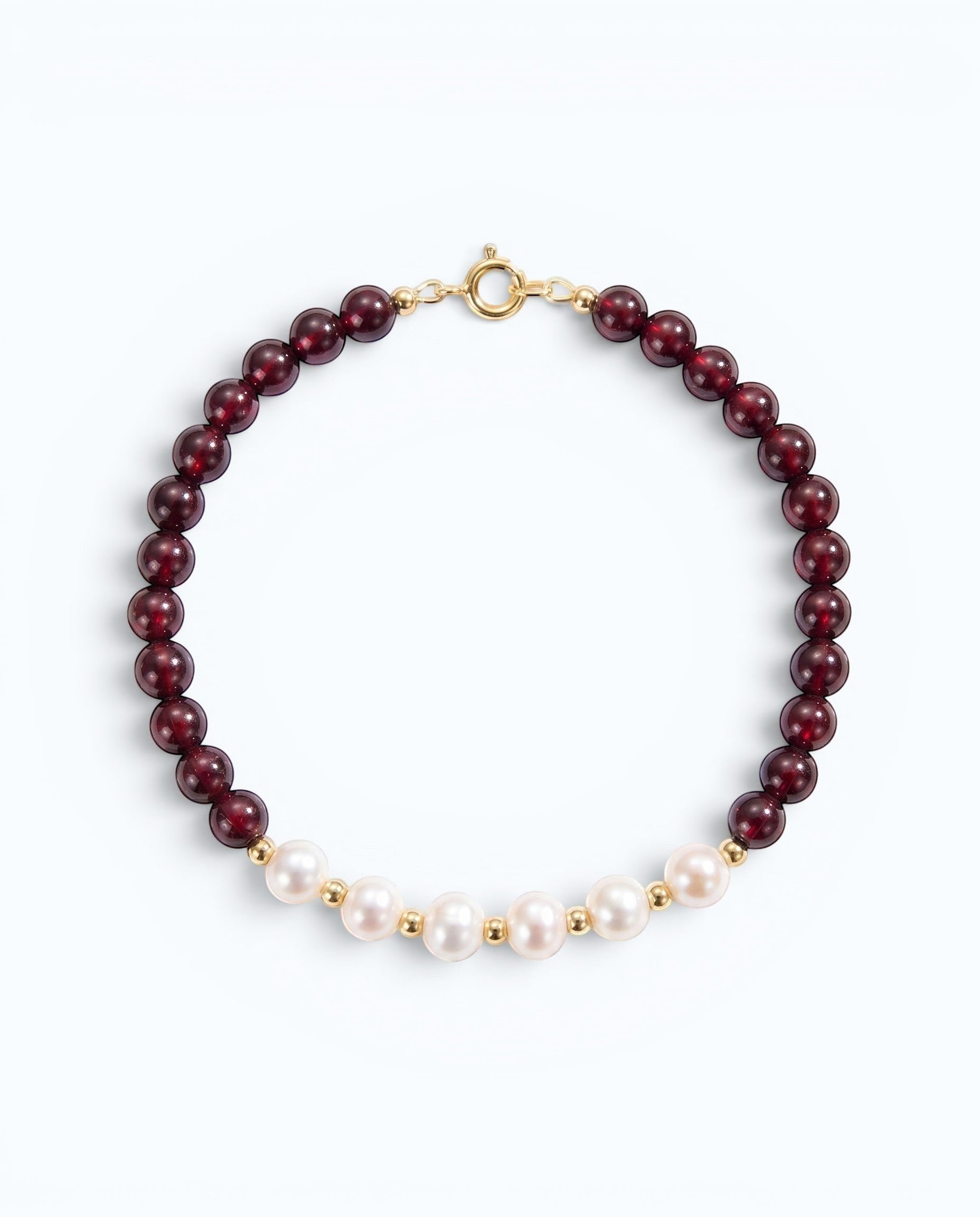 Pearlystones bracelet featuring deep red garnet beads and white pearls with gold-toned spacers and a secure clasp.