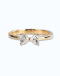 Pearlystones gold ring with a delicate bow design adorned with two heart-shaped gemstones.