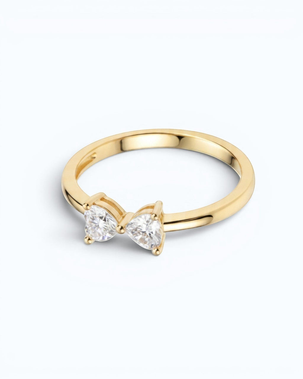 Pearlystones gold ring with a delicate bow design adorned with two heart-shaped gemstones.