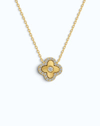 Pearlystones gold clover pendant necklace with laser-engraved sunburst rays, central zircon, and pavé zircon halo.