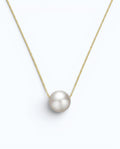 Pearlystones minimalist floating freshwater pearl necklace on a delicate gold-tone sterling silver box chain.
