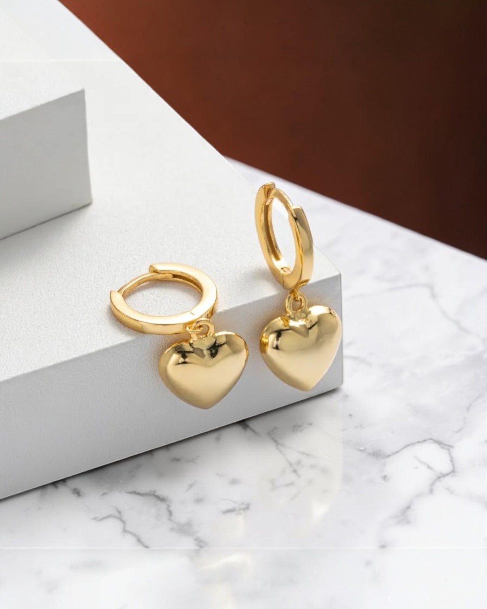 Pearlystones gold heart charm hoop earrings, crafted from sterling silver with a puffed heart charm.