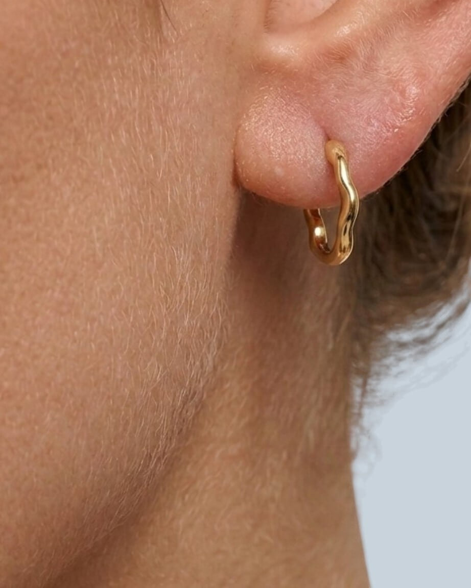 Pearlstones gold molten texture medium hoop earring with hinged creole closure.