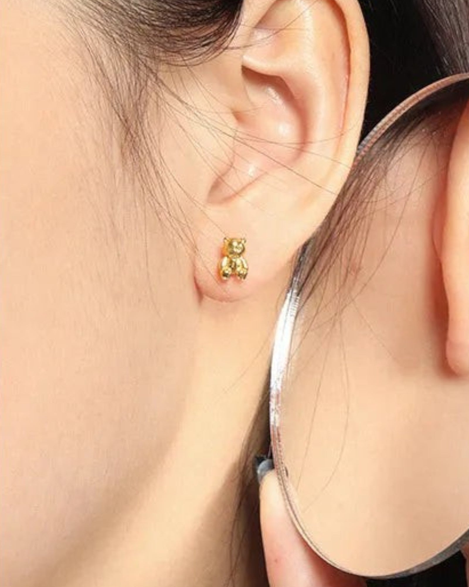 Pearlystones 18K gold plated 3D teddy bear stud earrings worn on a model's earlobe