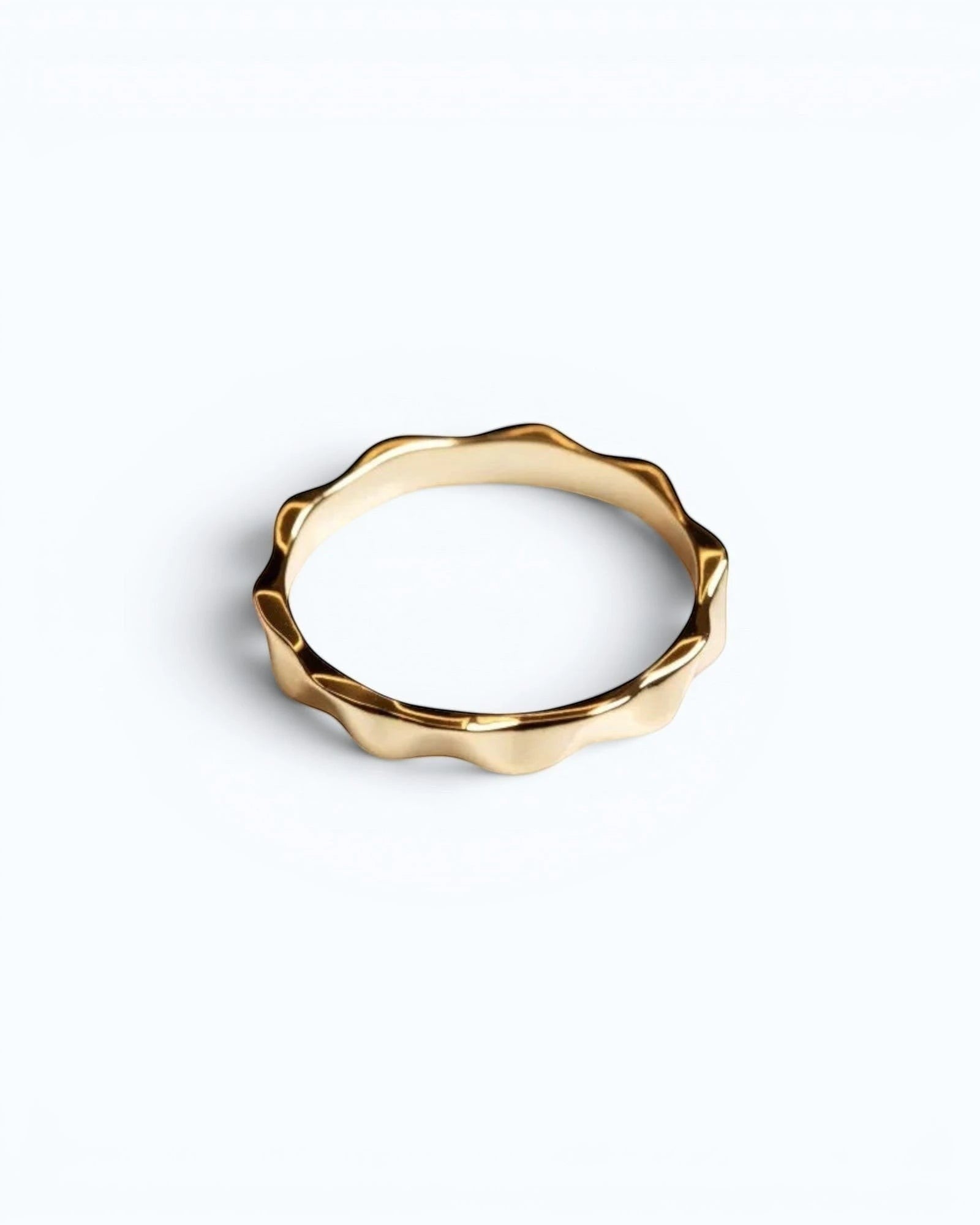 Pearlystones gold wavy band ring with geometric facets, a modern and elegant statement piece.
